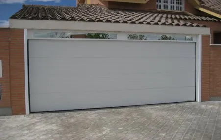 Portão seccionado branco numa moradia de tijolo